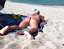 This babe shows her butt on the beach of Cap d'Agde and jerks off her cunt and then her boyfriend's dick with voyeurs