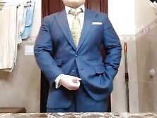 Сheerful business man fingering in a suit in front of a mirror