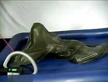 Woman struggling in a green latex bag