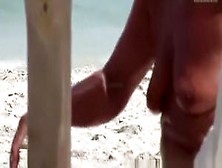 The old woman is walking topless on the beach