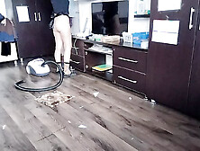 Amateur wife cleans the bedroom with the vacuum cleaner.
