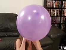 Good looking brunette blowing balloons