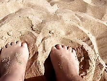 Provocative feet play in the sand,  in public.