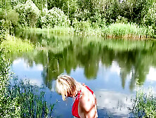 Swimming In Lake In Coral Color Summer Dress And White Sneakers.