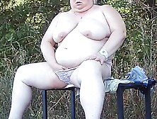 a ally in the park disrobes and masturbates on a bench