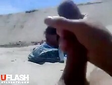 Lady takes pictures of chap flashing on the beach