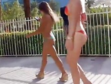Two sweeties walk around the town in revealing bikinis