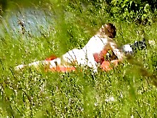 Outside. Wild beach. Random passerby dude by river saw in nature's garb woman sunbathing. Outdoor. Nudist