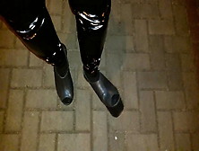 A Crossdresser In High Wedge Platform Shoes And Latex Leggings Is Walking The Streets At Night