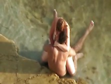 Gorgeous redhead is riding her fellow-ally on the beach